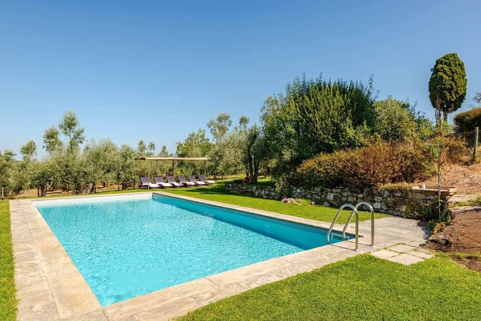 Vista complessiva della piscina privata con il portico e zona lettini