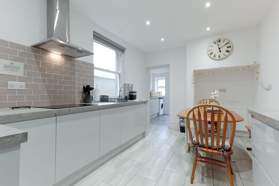 A fully equipped kitchen with a dining table and chairs for group meals