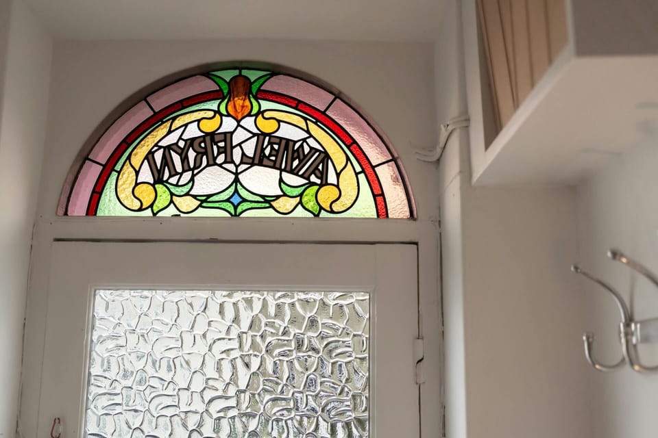 Front door fan light with cottage name in stained glass