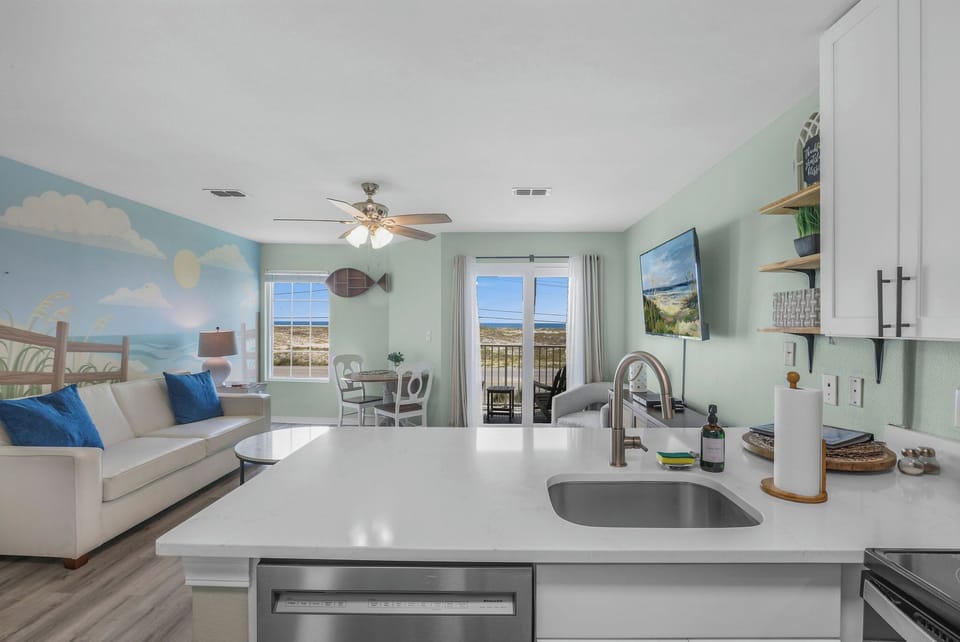 Living Room: Bright and inviting space with beachy decor and stunning views