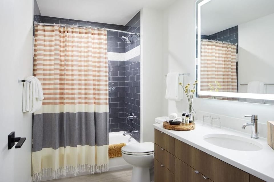 Refresh in a spotless bath with bright vanity lighting.