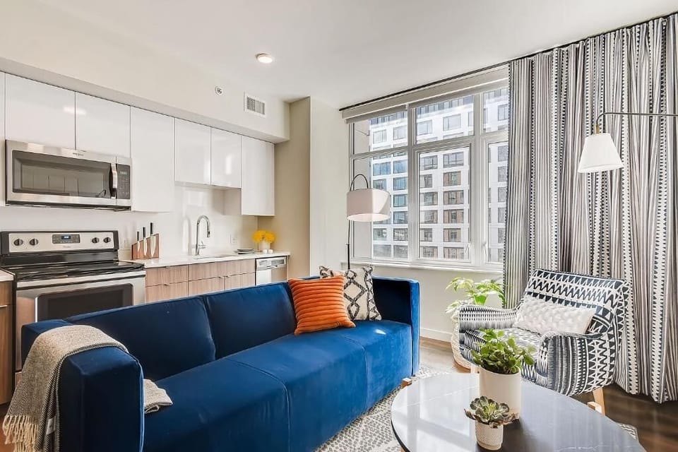 Gather on the plush sofa beside bright, city-view windows.
