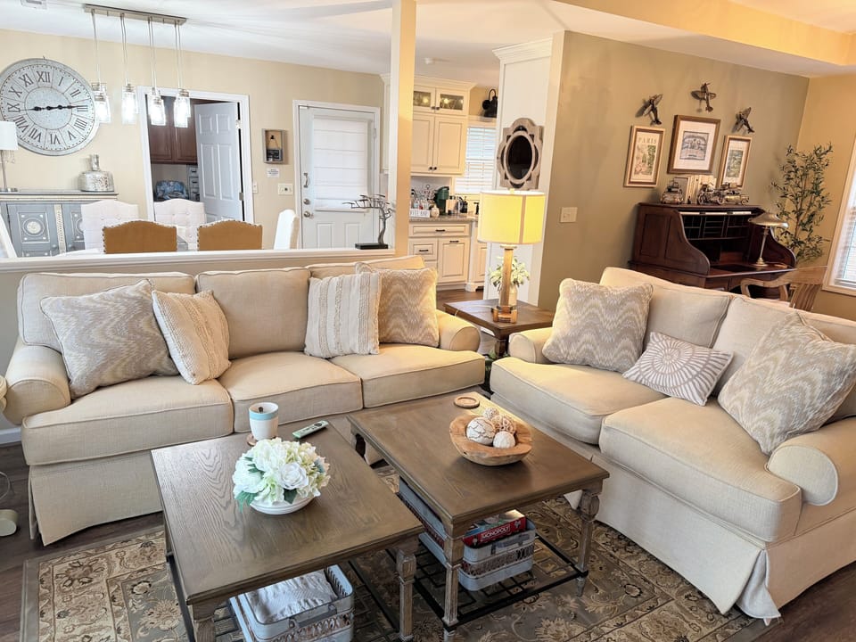 This cozy living room has cushy seating & a view of the pond. Also a large TV.