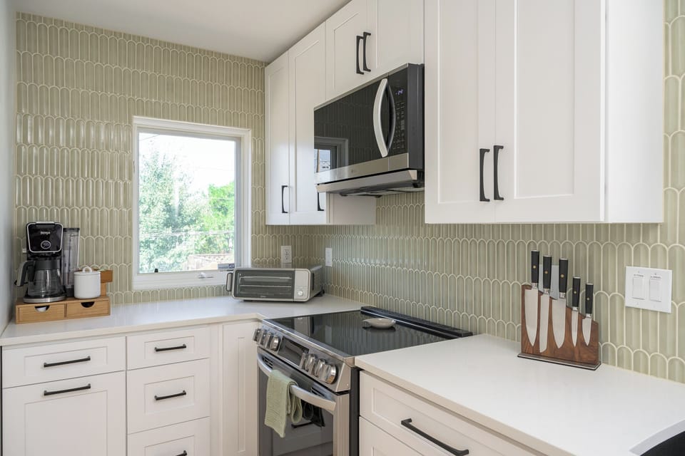 Bright kitchen cooking area with modern appliances, gas range, and ample counter space.