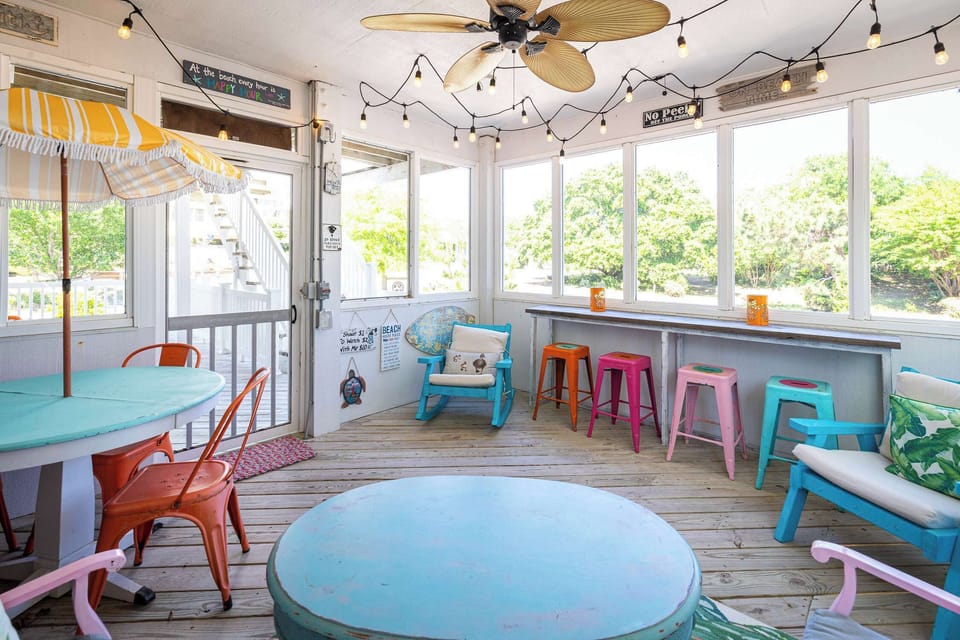 Mid Level: Sunroom with comfortable seating, dining area, and bar-style seating