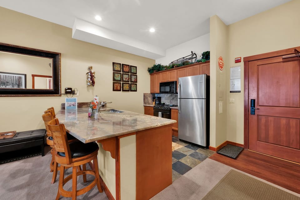 Fully stocked kitchen and island with bar stools and electric stove. Perfect for cooking any meal!