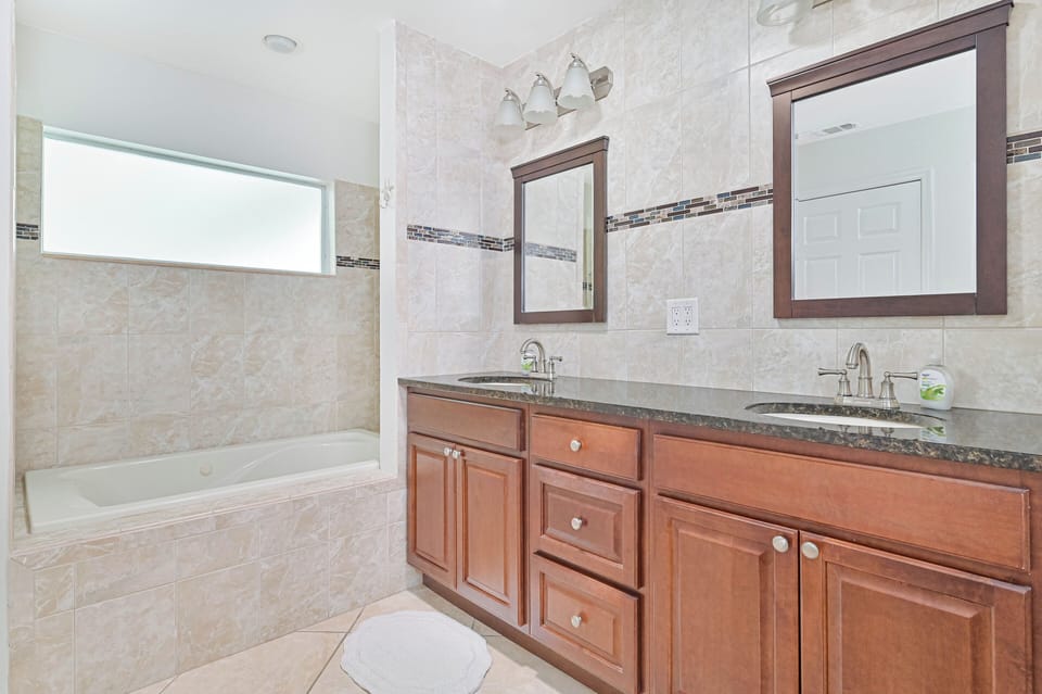 Coral Cove - The en-suite primary bathroom features double sinks, a soaking tub (not jetted), and a large walk-in shower