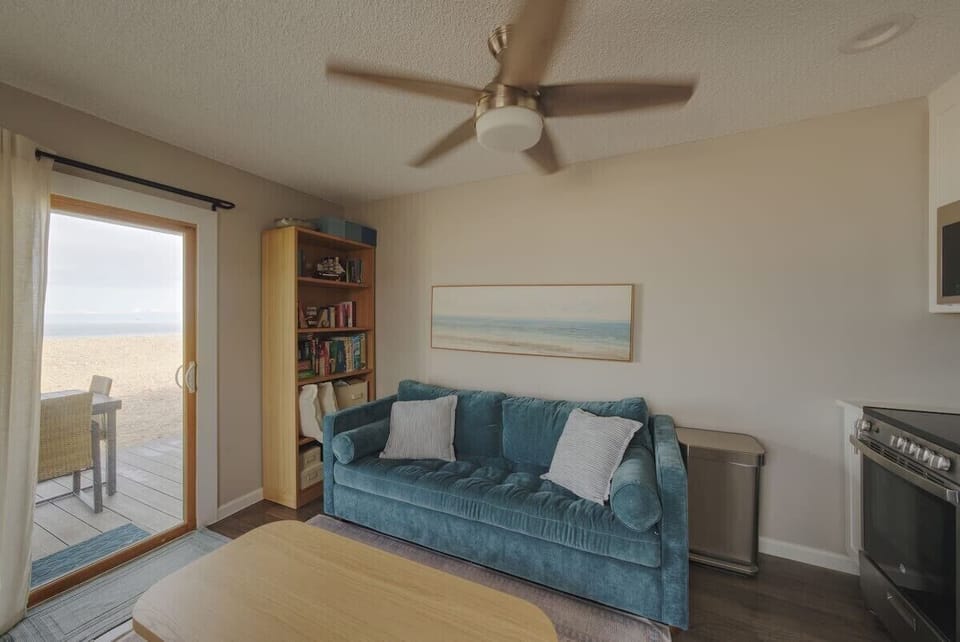 Cozy coastal living room with water-view patio access