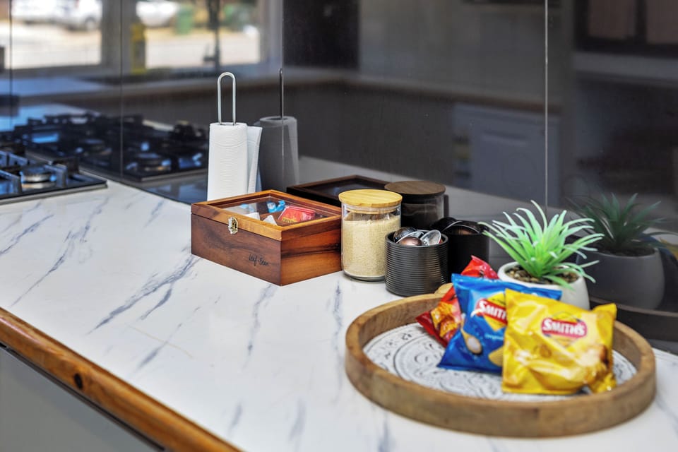 Enjoy complimentary tea, coffee, sugar, and snacks—all neatly arranged on our stylish kitchen countertop.