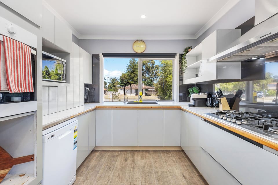 Bright, fully equipped kitchen with modern white cabinetry and a gas stovetop—ready for your culinary creations!