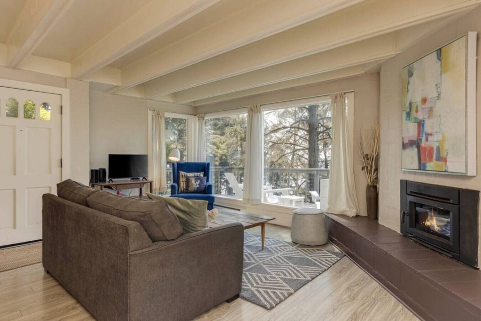Unwind in the living room with plenty of comfortable seating and large windows that look out onto the trees. The fireplace adds charm and makes this space perfect for relaxing together after a day of exploring.