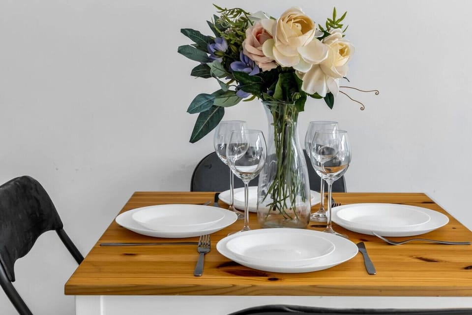 Elegant Dining Setup with Fresh Flowers and Tableware for Four | Managed by Rentujemy