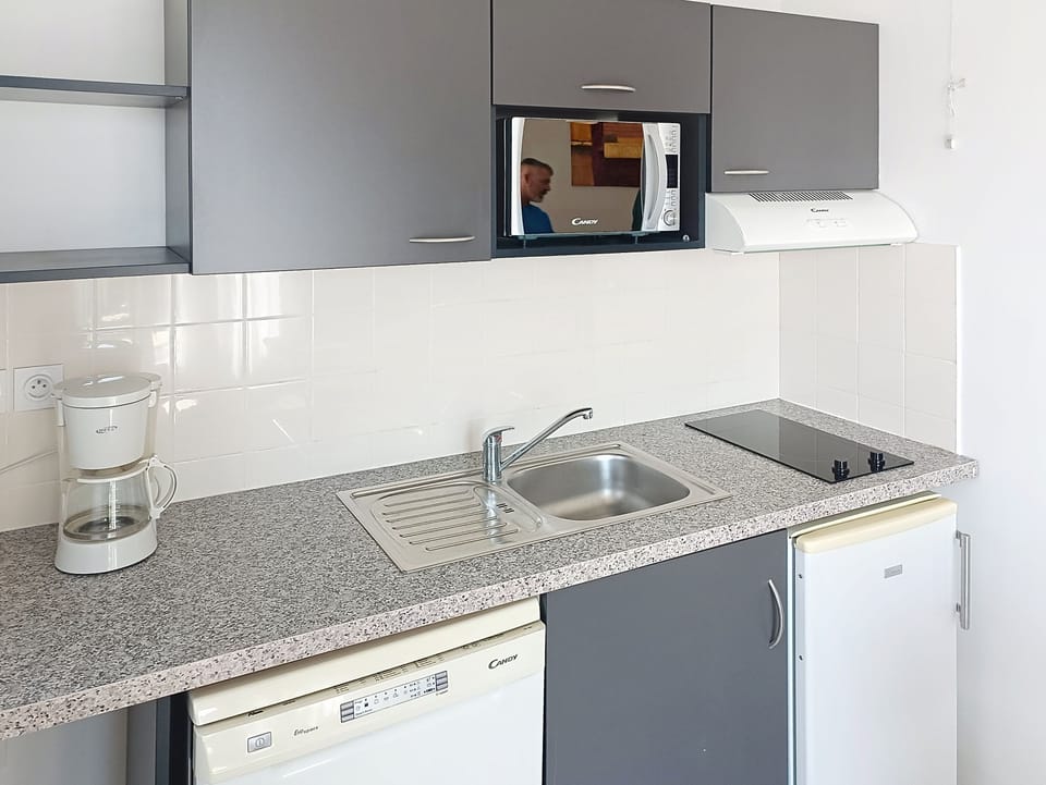 Kitchen counter with coffee maker, sink, and appliances.