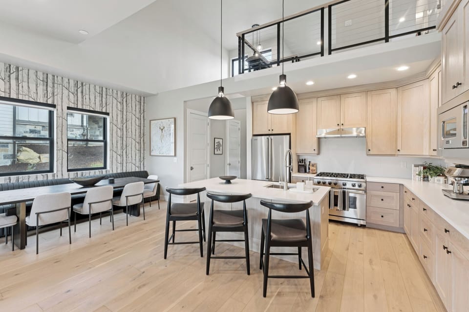 Chef's kitchen with large island, pendant lights, and bar seating.