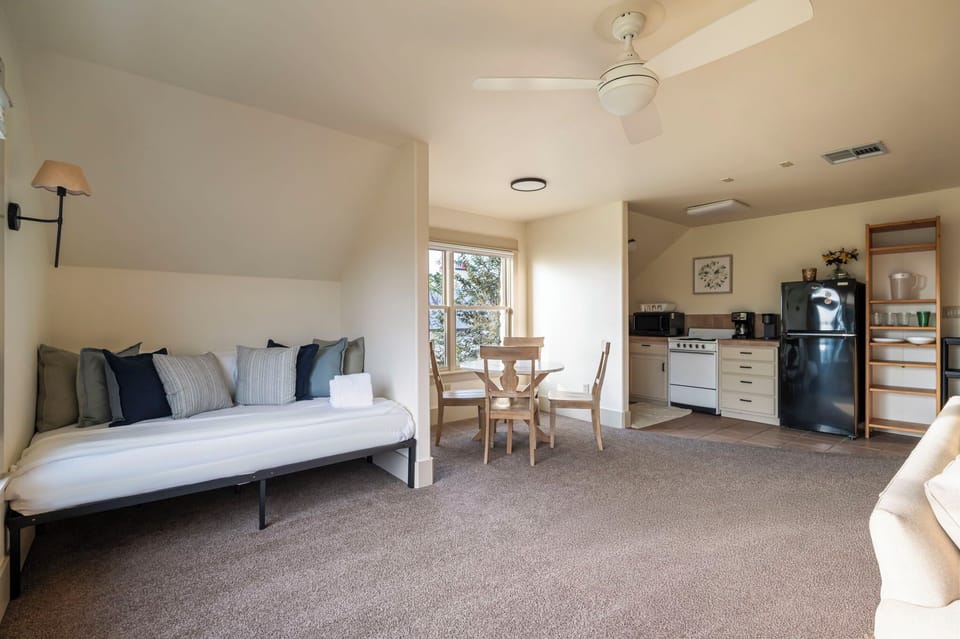 A private and spacious apartment above the garage featuring a queen daybed, a TV, two armchairs, and a three-person sofa for comfortable lounging.