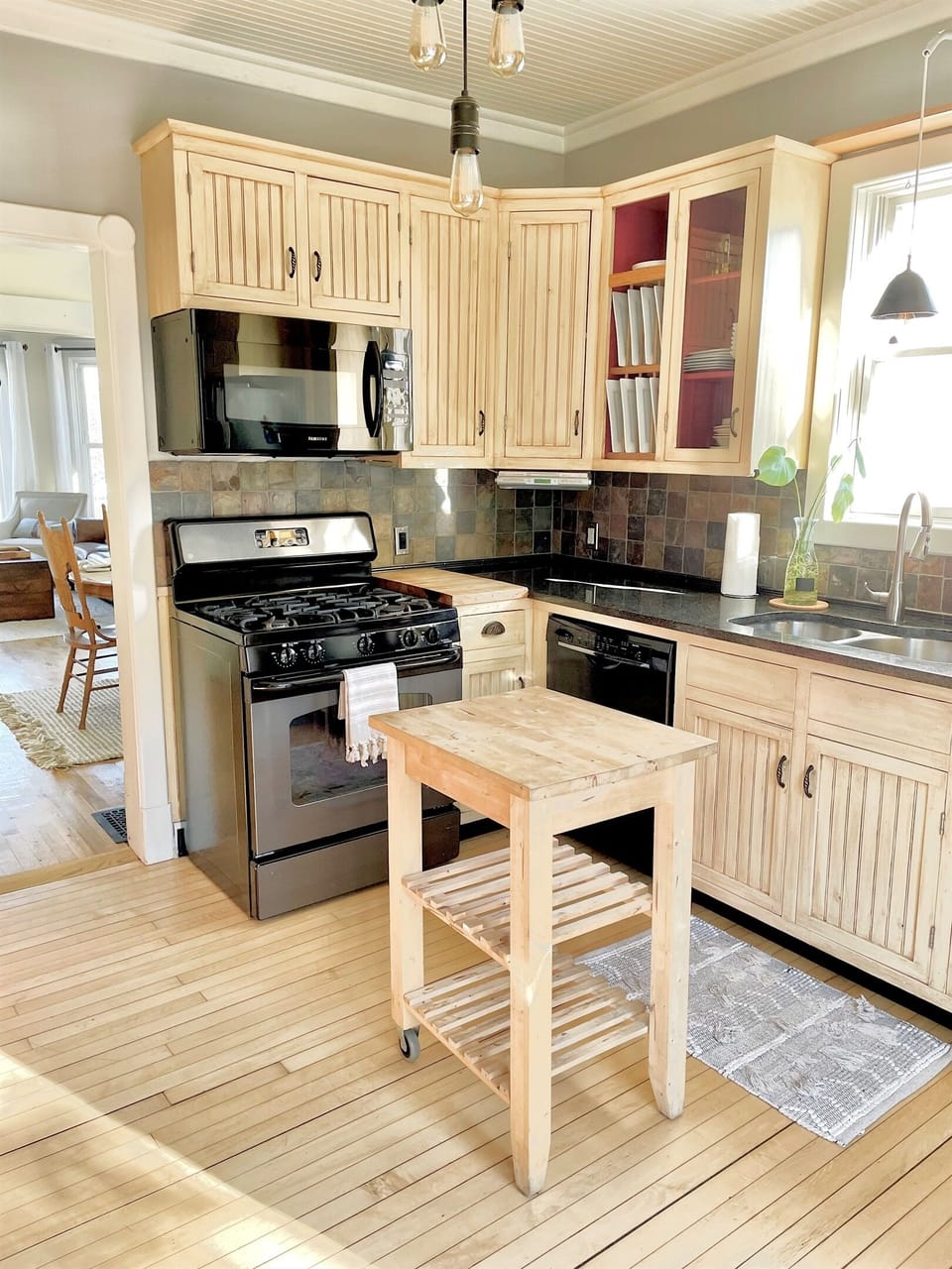 Fully-equipped kitchen with custom-made cabinetry, stove top oven with griddle, large refrigerator, prep butcher block, bar and loads of cooking pans and baking supplies.