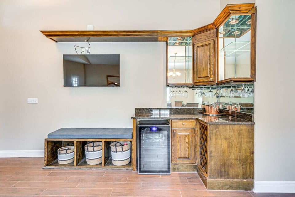 Sleek wet bar with wine fridge & glassware storage—entertain in style! 🍷