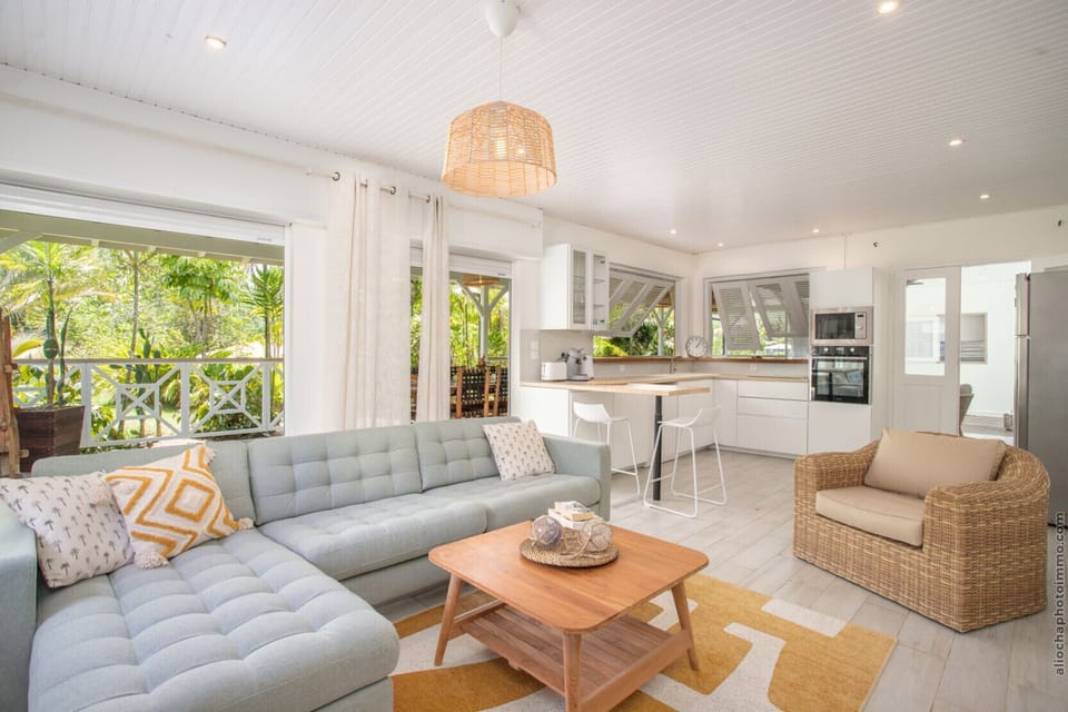 A living room blending Creole and contemporary style, opening onto the tropical garden