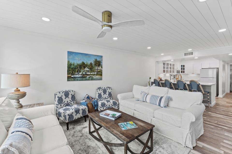 Decorated with coastal art and a rustic coffee table.