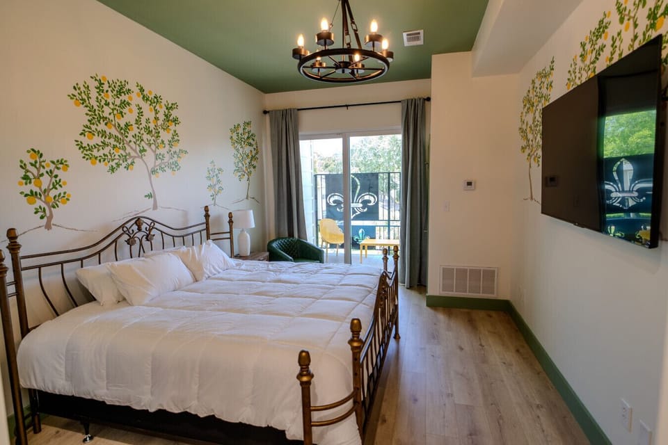 Features a King bed, hand-painted mural, and cozy finishes with balcony access