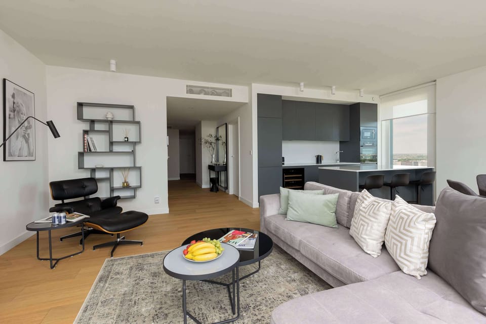 Another view of the spacious living room showing the arrangement of sofas, a coffee table all designed with a monochrome color palette.