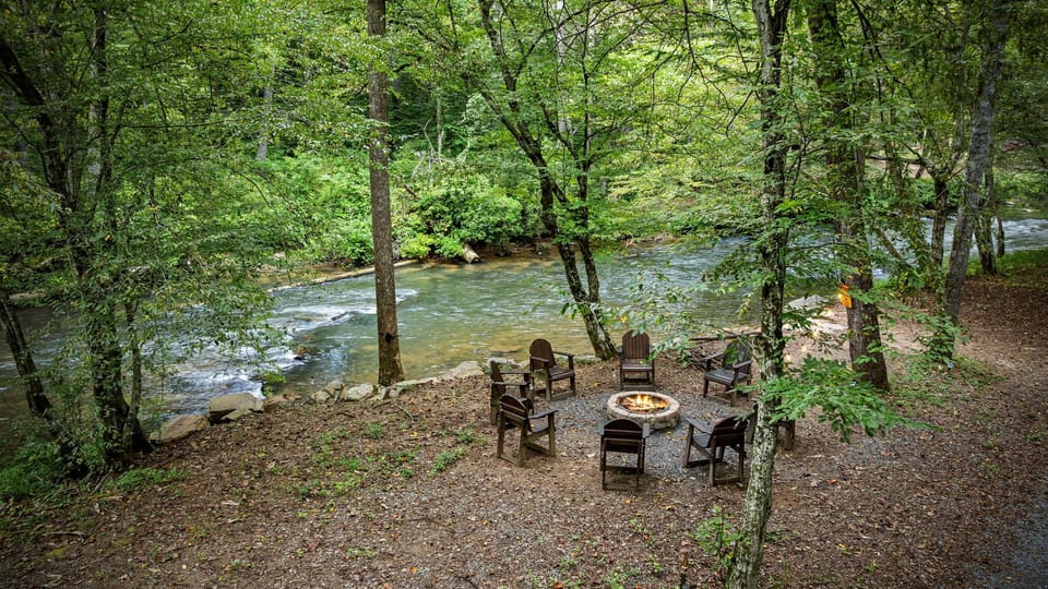 Fireside nights under string lights by the creek 🔥
