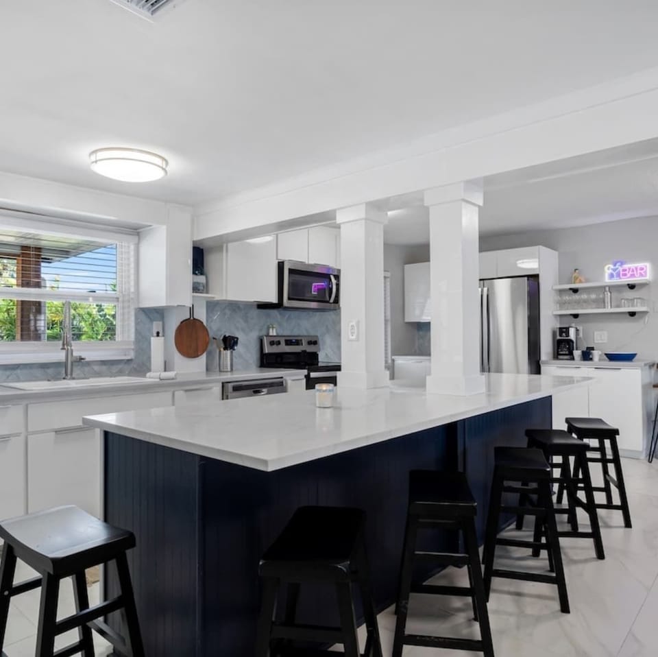 Bright, open kitchen with pool and canal views—fully stocked for family meals and gatherings.