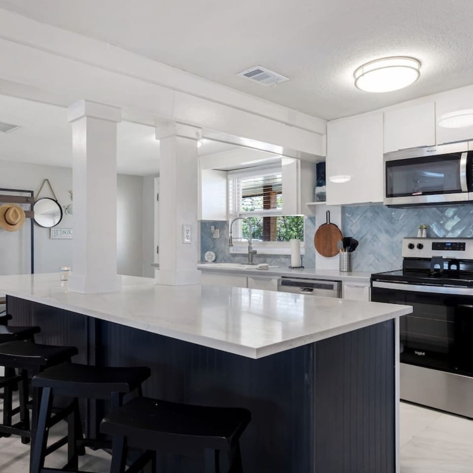 Bright, open kitchen with pool and canal views—fully stocked for family meals and gatherings.