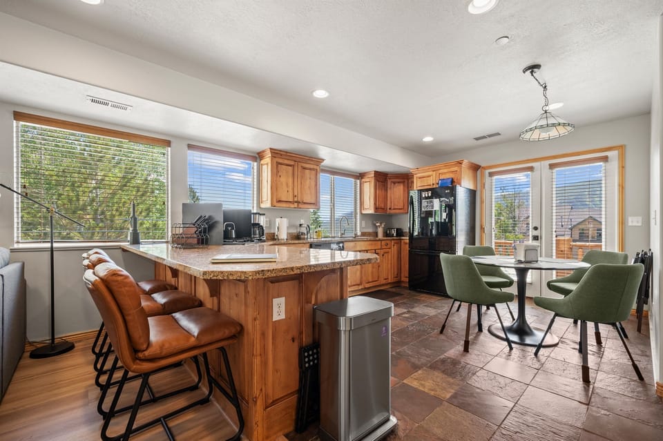 The gourmet kitchen features a breakfast bar with seating and is equipped with appliances, including a microwave, gas stove, and spacious refrigerator.
