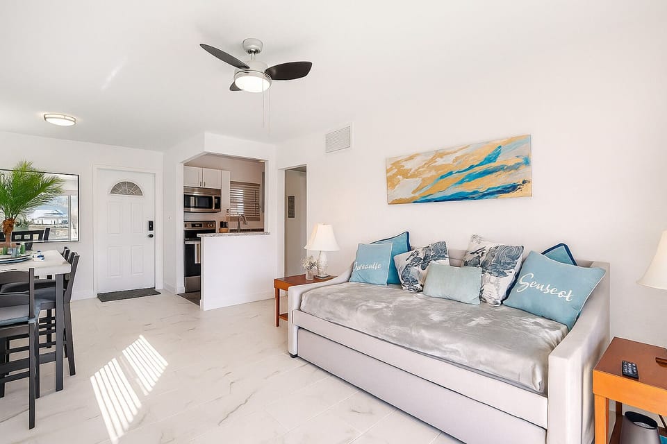 Open living room with stylish fold out trundle bed and beach inspired accents