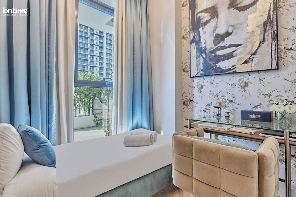 A cosy second bedroom featuring a single bed, a workspace with a desk and chair, and access to a common bathroom.