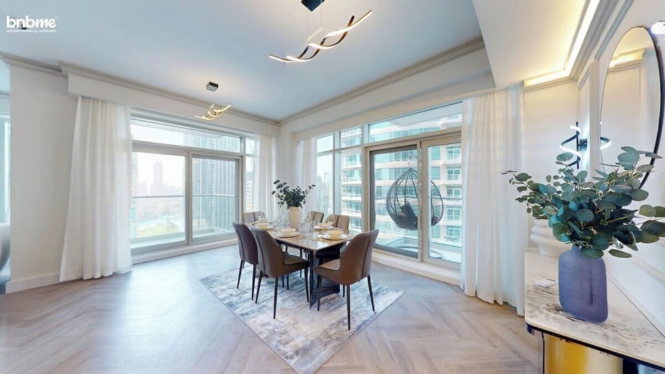 Gather around the elegant dining table set for six, surrounded by floor-to-ceiling windows that flood the space with natural light—perfect for enjoying family meals or hosting friends in your stylish Downtown Dubai apartment.