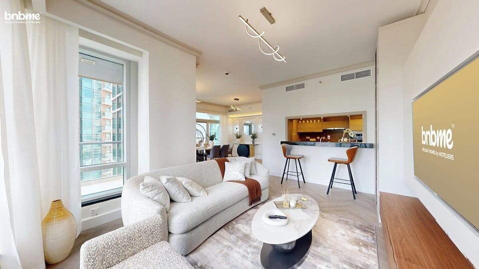 Step into a sunlit space with floor-to-ceiling windows, premium sofa, sleek Smart TV, and contemporary décor. Perfect for relaxing, streaming, or soaking in Downtown Dubai skyline views—ideal for families, couples, and remote workers.