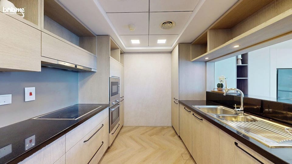 Step into the sleek, modern full kitchen featuring built-in appliances, a ceramic cooktop, stainless steel sink, and ample storage—perfect for extended stays and home-cooked meals in your Downtown Dubai holiday apartment.