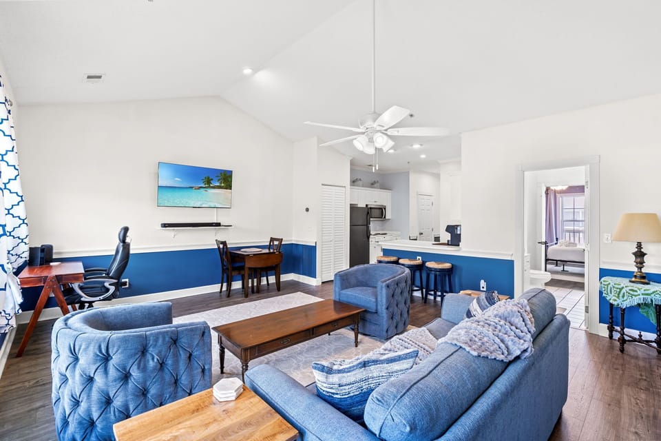 Open layout with cozy seating, workspace, and easy access to kitchen & dining.