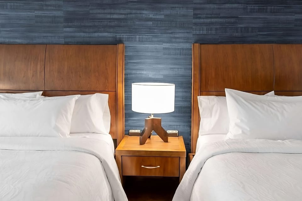 Unwind between plush pillows with warm bedside lighting.