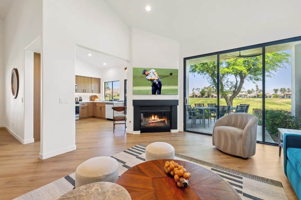 Natural light floods the space through floor-to-ceiling windows opening to the patio.