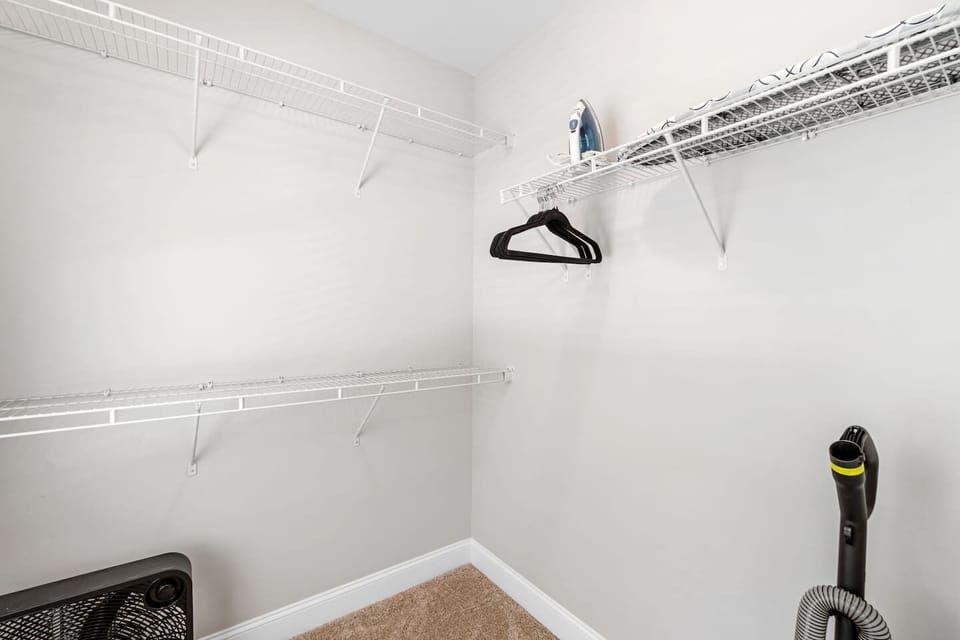 Main bedroom closet - iron, ironing board, hangers, vacuum