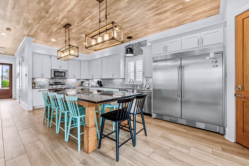 1st Floor – Spacious dining room and gourmet kitchen with premium appliances, large island, and plenty of seating. Perfect for family meals, entertaining, and group gatherings during your Miramar Beach vacation.