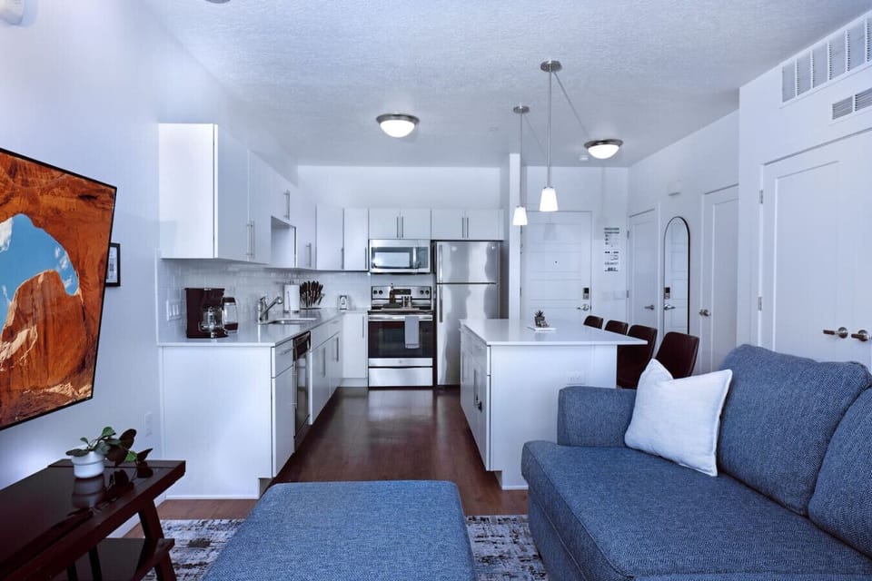 Beautifully designed living room. 65` TV,  sofa and amazing views of mountains and city skyline.