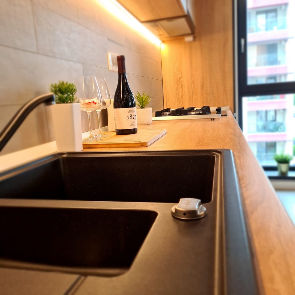 Enjoy a glass of wine in the modern kitchen with warm, cozy lighting.
