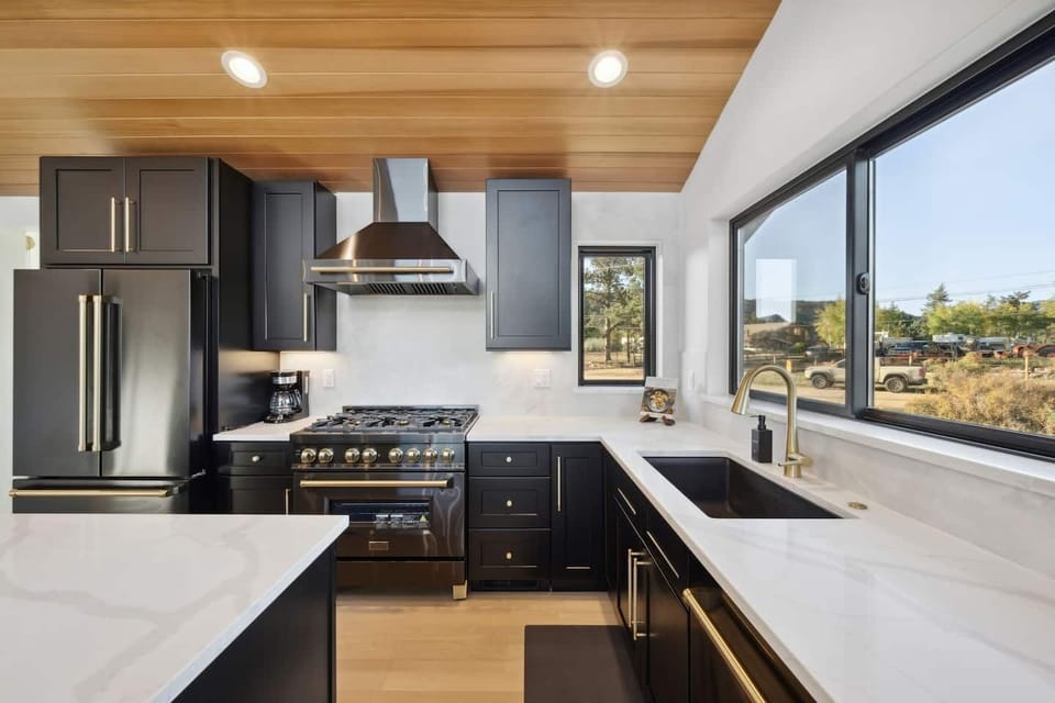 A fully equipped kitchen where wide windows bring the outdoors in.