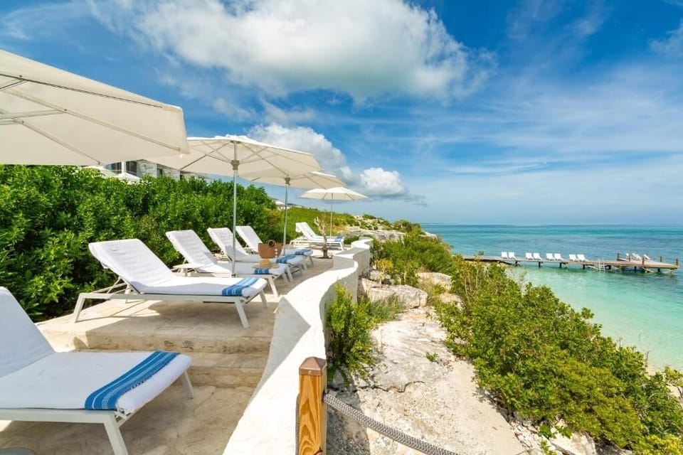 Lounge seaside with shaded daybeds and cooling sea breezes.