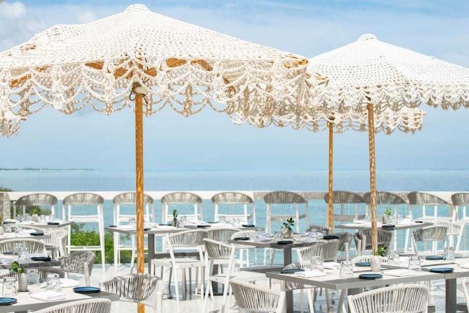 Dine alfresco beneath breezy umbrellas with panoramic sea views.