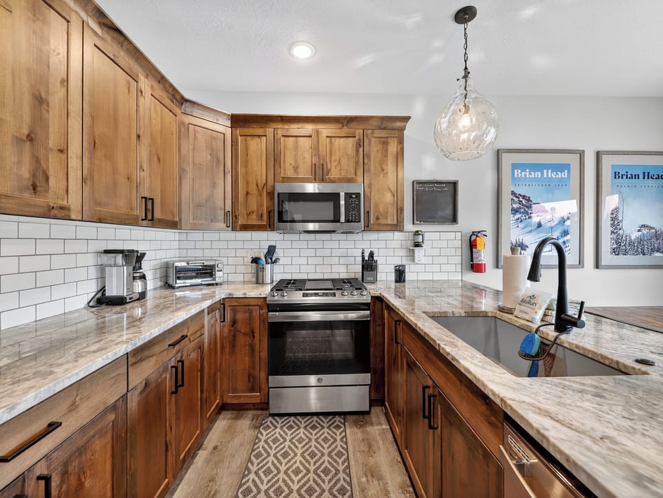 Fully stocked kitchen with sleek stainless steel appliances, custom cabinetry, and beautiful countertops—perfect for preparing meals and gathering together