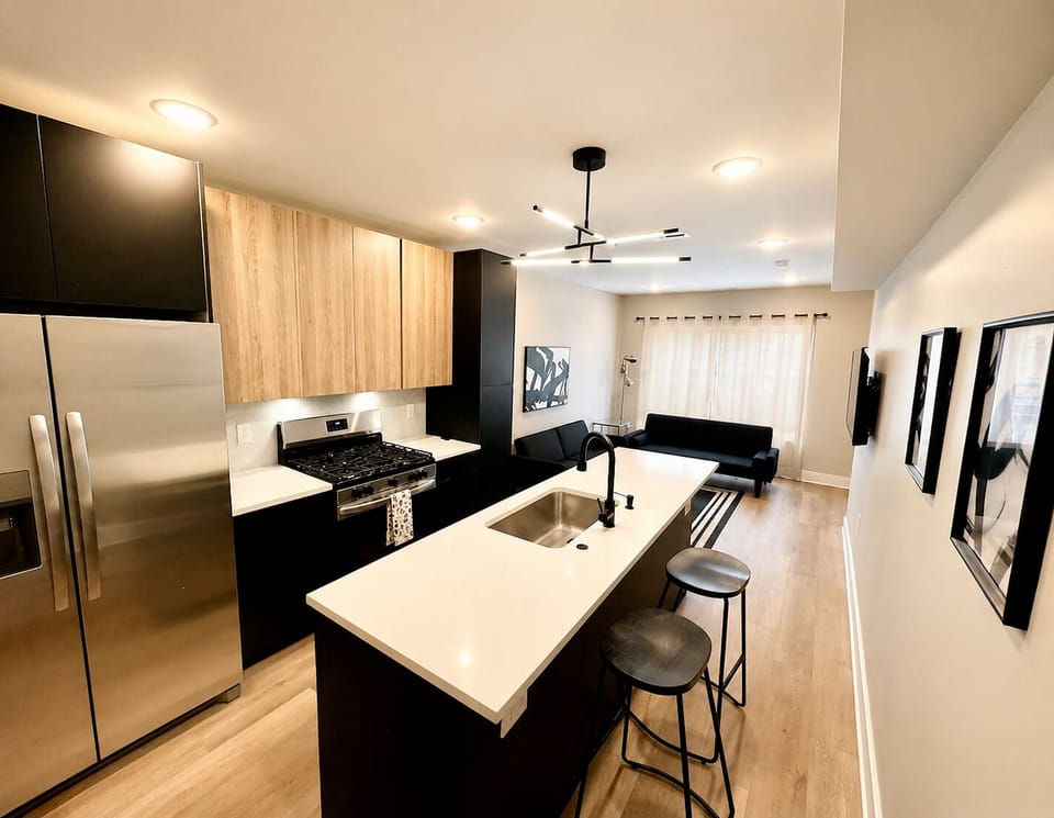 The living room is tastefully furnished with two futon sofa beds, a spacious 50-inch television featuring a wide selection of Ruku channels, and an abundance of invigorating natural light that gracefully floods the room through the large windows.