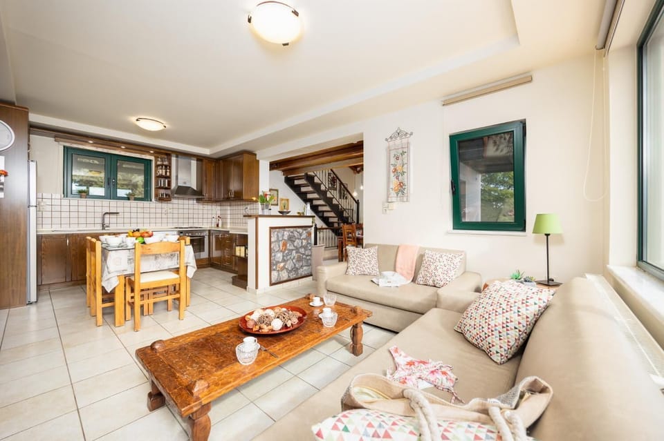 Open-plan living room with sofas, dining areas, kitchen, ornamental fireplace, A/C, WiFi internet, and satellite TV