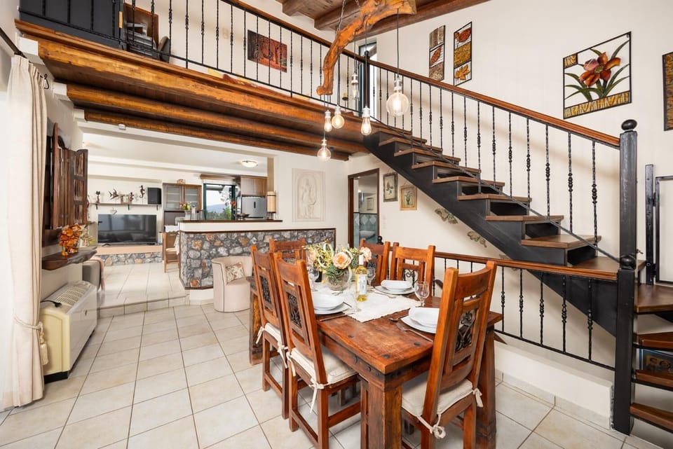 Open-plan living room with sofas, dining areas, kitchen, ornamental fireplace, A/C, WiFi internet, and satellite TV