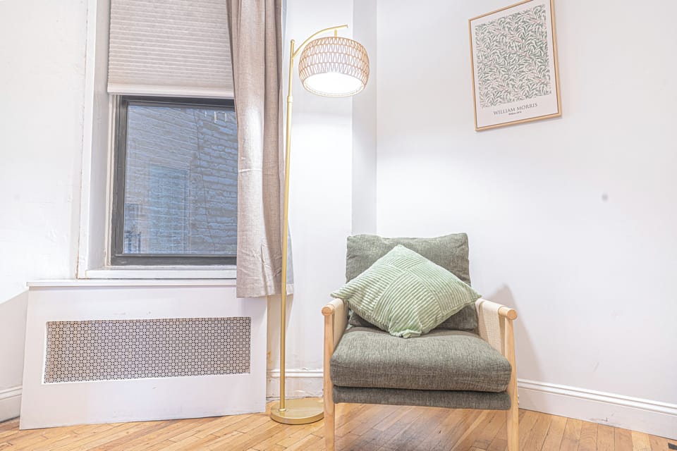 Cozy reading nook with armchair, lamp, and accent pillow for quiet relaxation