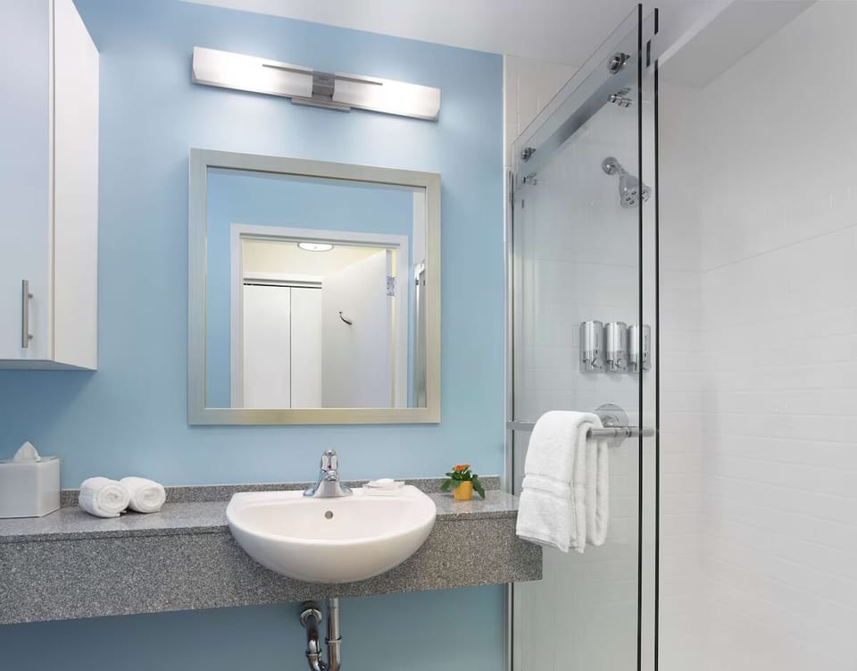 Refresh in the spotless glass shower with bright vanity lighting.